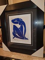 Full view of the professionally framed print showing black wooden frame and protective corner guards.