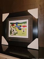 Framed fine art print shown with protective corner covers, side angle view
