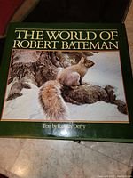 Front cover of 'The World of Robert Bateman' hardcover book with green cover and painting of squirrels on snowy tree branches