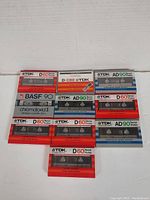 Top view of 10 sealed cassette tapes from TDK and BASF showing front labels and cases.