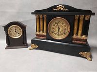 Both antique clocks shown side by side on a neutral surface.