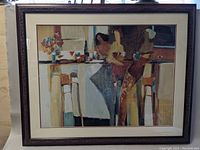 Framed print showing abstract bar scene with three women, main focus on central female figures with drinks in hand