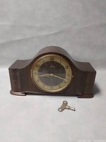 Front view of Mauthe Art Deco mantel clock with winding key placed in front.