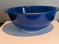 Side view showing the deep blue color and smooth curvature of the Pyrex mixing bowl.