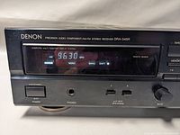 Close-up of the front left section of the Denon receiver showing the power switch, headphone jack, speaker selectors, and bass control knob with the frequency display set to 96.30 MHz.