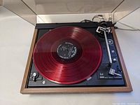 Top view showing red translucent demo record on platter and wood-trim plinth