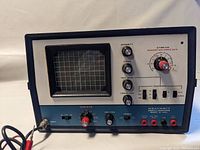 Front view showing CRT screen, control panel with knobs and switches, and input/output connectors.