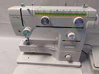 Front view showing stitch selection chart, dials and needle area