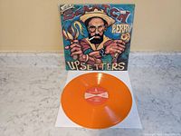 Front view of orange vinyl record with illustrated album cover showing Lee Scratch Perry and Upsetters text