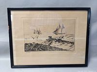 Framed etching showing two sailboats on the ocean, surrounded by a white mat and black frame.