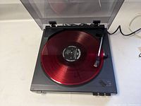 Top view of Teac PA 688 turntable playing a red vinyl record (not included).