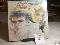 Front cover of Air Supply Greatest Hits LP, showing illustrated portraits of two men and the album title.