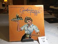Front cover of the American Graffiti soundtrack showing a waitress holding a tray with drink and milkshake on orange background