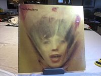 Front cover of The Rolling Stones "Goatshead Soup" LP record showing stylized image of Mick Jagger's face.