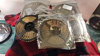 Five rolls of LED strip lights in sealed plastic bags on a plaid surface.