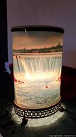 Front view of the lit Niagara Falls Econolite light showing waterfall and cityscape.