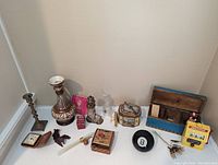 Overview of assorted vintage household and decorative items showing entire grouping as seen on flat surface against wall.
