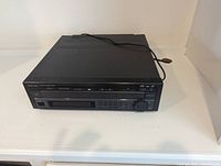 Front view of black Mitsubishi Laserdisc player showing buttons, display, and rotary knob.