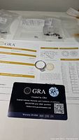 GRA grading report sheet and warranty card with ring on top