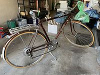 Full side view of the vintage Raleigh bicycle showing the entire frame, wheels, rear rack, and pedals.