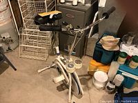 Full view of the Get Fit exercise bike showing white frame, black seat, and black foam handle grips with mechanical dials.