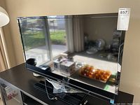 Full view of Toshiba 40 inch TV on black stand showing screen and bezel details.