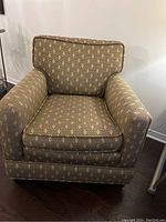 Front view of beige patterned armchair showing overall design and condition.