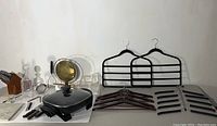 View of metal gong with brass tone gong surface on black stand, assorted hangers laid out flat, stone board, and knife block with knives visible.