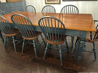 Front view of full dining table with matching chairs in background