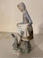 Front view of Lladro figurine showing girl and rabbit standing on detailed base