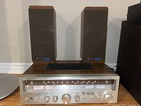 Front view of the Sanyo AM/FM stereo receiver and the pair of Koss Dynamite bookshelf speakers showing overall condition and appearance.