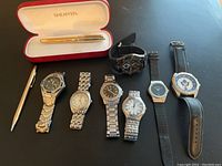 Photo showing all items in the lot: 6 wristwatches lined up side by side and 2 writing instruments, including Sheaffer Prelude pen in red case and a silver Cross pencil.