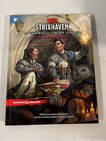 Front cover of the Strixhaven: A Curriculum of Chaos D&D hardcover book showing detailed fantasy artwork and official logos.