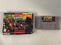 Donkey Kong Country 2: Diddy's Kong Quest SNES game cartridge and original box on a flat surface.
