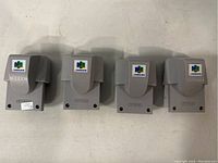 Four grey Nintendo 64 Rumble Paks laid side by side with N64 logo visible on top front.