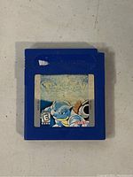 Photo of Nintendo Gameboy Pokemon Blue cartridge showing front label and blue plastic body with wear.