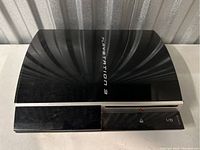 Top view of black Sony PlayStation 3 console showing front panel with power button and disc slot.
