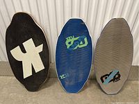 Photo shows three skimboards side by side with distinct textured surfaces and logos.