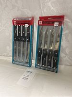 Two unopened sets of J.A. Henckels International Eversharp Pro knives in original packaging, placed side by side on a white cloth background