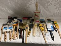 Photo showing full layout of all paint brushes in the lot on a white surface.