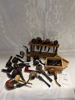 Full view of smoking pipes spread out with pipe stand and box of parts
