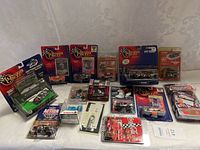 Overview image showing all included NASCAR die-cast cars in their original packaging along with other collectibles like 'The Magnetic Man' and a fidget spinner.