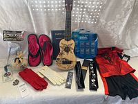 Photo showing entire assortment of items including ukulele, sandals, gloves, jewelry, and clothing