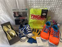 Photo showing Nike men's size 12 orange and blue athletic shoes, Converse kids' navy blue size 2.5 shoes, Daniel Green women's gold sandals size 10, Tingly jacket in package, gloves and other clothing items.