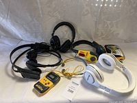 Photo showing six items: Sony over-ear headphones, on-ear headphones, yellow Sony Sports Walkman, and three sets of wired headphones/earbuds.