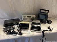 Wide view showing the entire lot including radios, cassette players, and Watchman TV