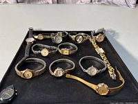 Overview photo showing all 12 women's watches arranged on a black mat, highlighting various band and watch face styles.