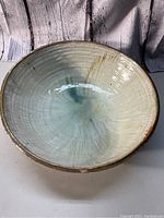 Top view of the ceramic bowl showing the internal glaze finish with cream and blue-green tones, with visible circular texture lines.