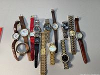 View of all 11 collectible watches laid out on a white surface, showcasing various styles and bands from leather to metal.