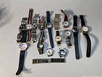 Full lot view showing all 15 watches arranged in rows, variety of strap materials and dial designs visible.